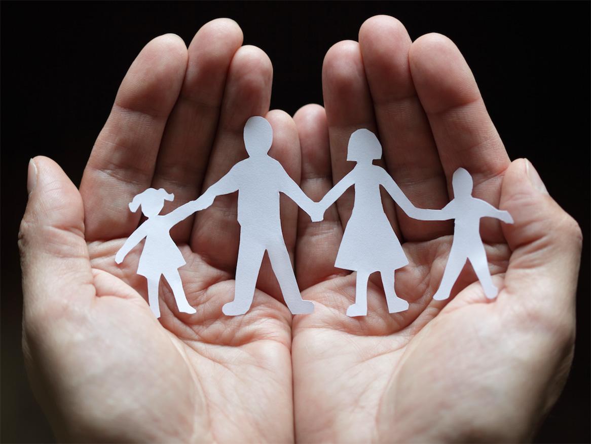 Hands holding cut out paper of family